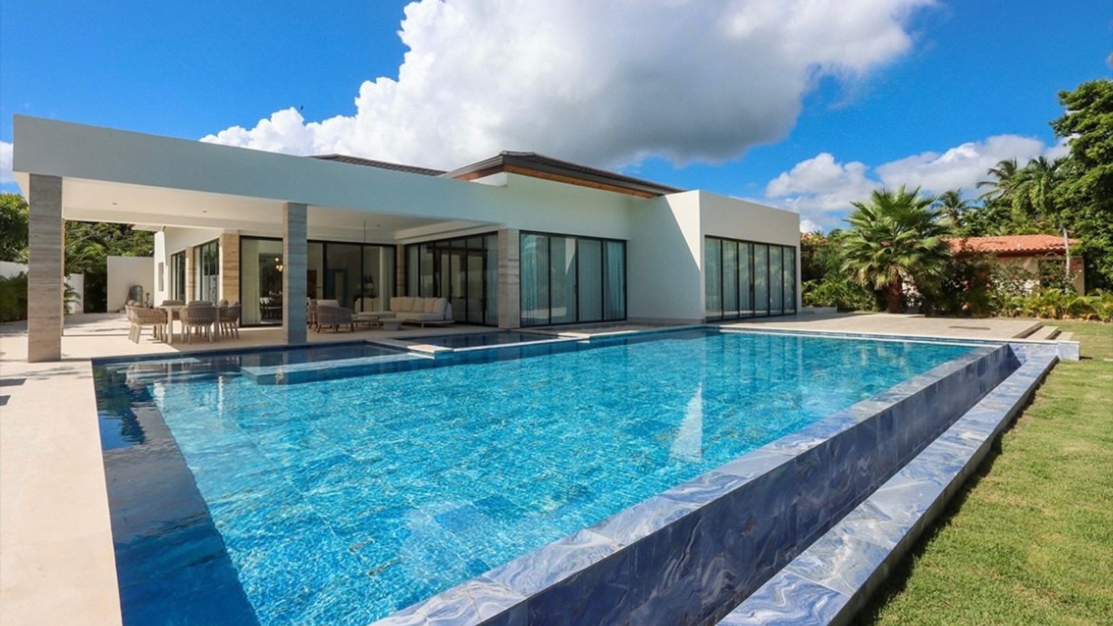 Villa contemporánea de una planta junto a una piscina alargada y un jardín